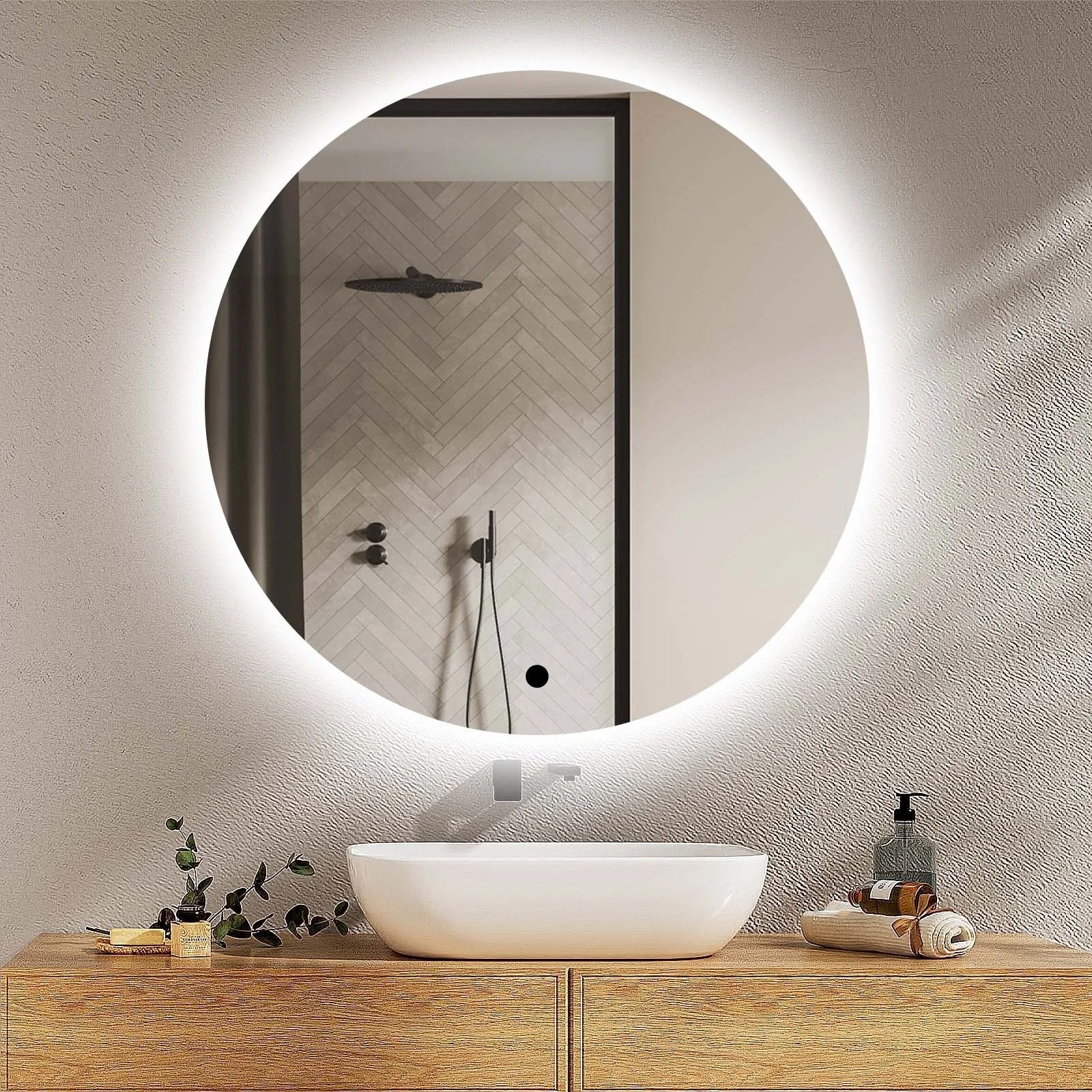 Round illuminated K-VIT bathroom mirror above a wooden vanity with a bowl sink.