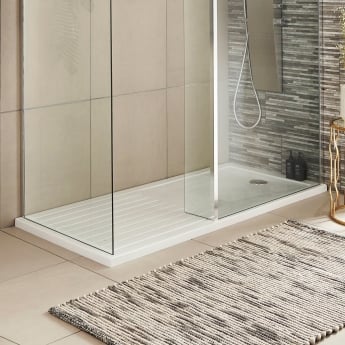 a wetroom shower tray on a beige tiled floor