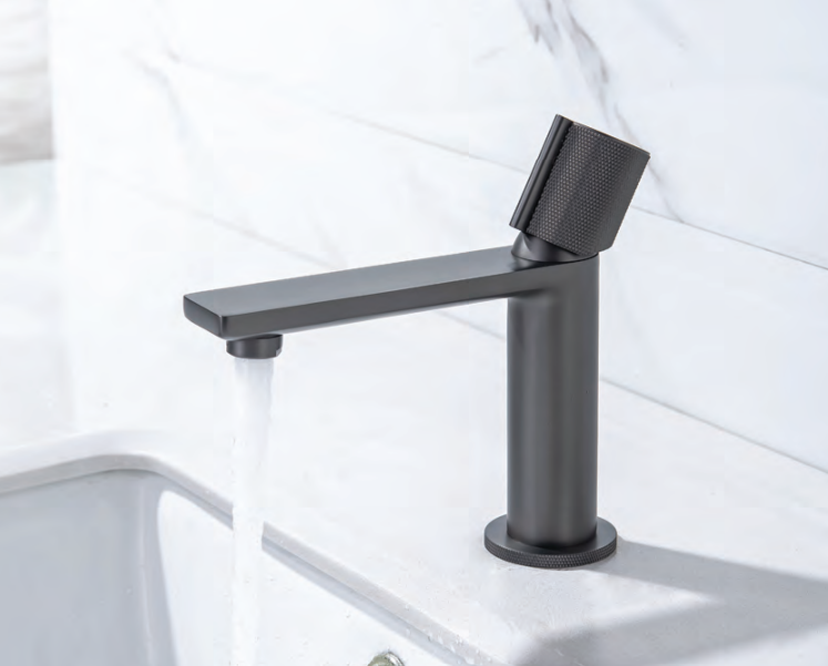 Black faucet on a white sink with a white tiled wall background