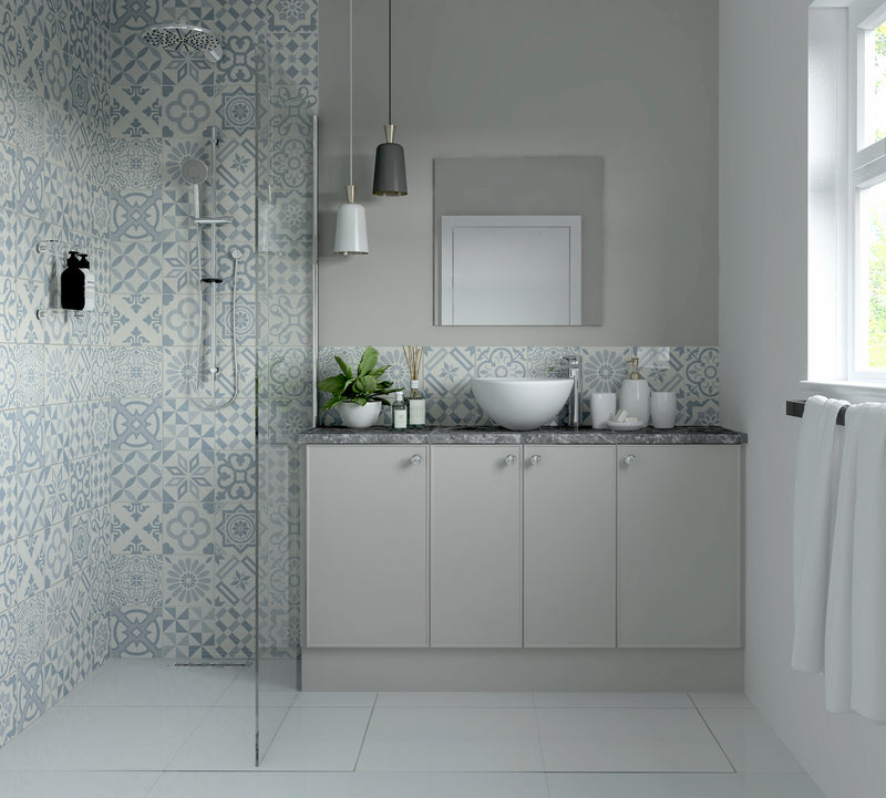 bathroom with gray fitted cabinets, patterned tiles, and a sink.