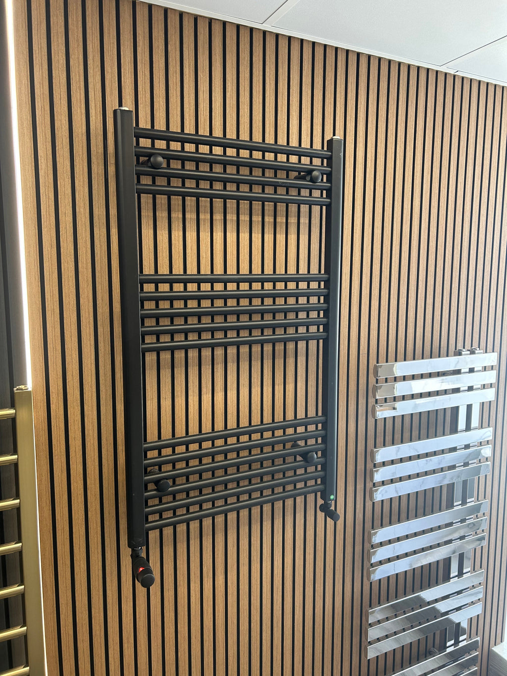 oak slat wall with two towel rails hung on it