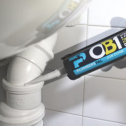 Plumbing tool labeled 'OB1 Plumbers'Pal' being used on a pipe against a tiled wall.
