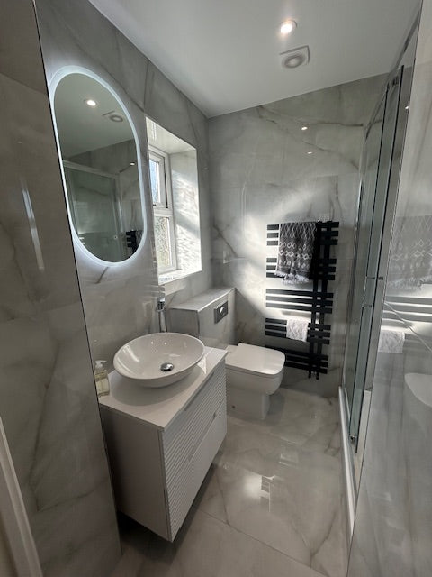 Modern bathroom with a bathtub, toilet, and shower area.